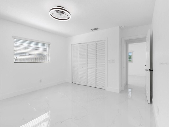 302 Patty Dr, Oldsmar, FL 34677 - unfurnished bedroom featuring marble tiled flooring and a closet