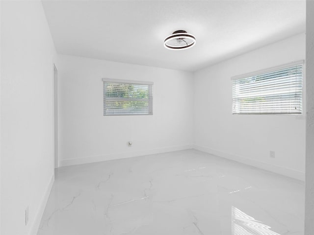 302 Patty Dr, Oldsmar, FL 34677 - spare room with plenty of natural light and light marble finish flooring
