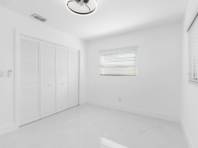 302 Patty Dr, Oldsmar, FL 34677 - unfurnished bedroom with marble finish flooring and a closet