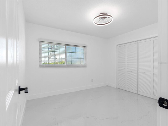 302 Patty Dr, Oldsmar, FL 34677 - unfurnished bedroom with marble tiled flooring and a closet