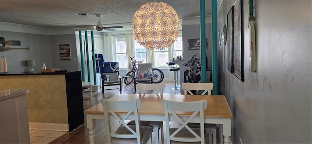 5501 80th St N Unit 207, Saint Petersburg, FL 33709 - dining room with a chandelier, crown molding, a textured ceiling, ceiling fan, and tile patterned flooring