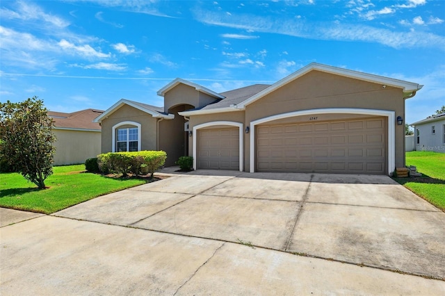 ranch-style home featuring stucco siding, an attached garage, driveway, and a front lawn