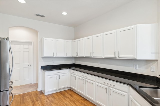 kitchen with freestanding refrigerator, light wood-style floors, white cabinetry, recessed lighting, and a sink