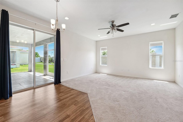 spare room featuring baseboards, a chandelier, wood finished floors, ceiling fan, and recessed lighting