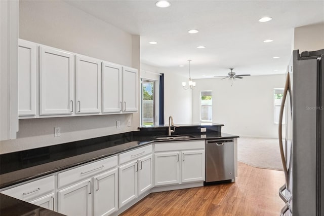 kitchen featuring stainless steel appliances, a sink, light wood-style floors, recessed lighting, and white cabinets