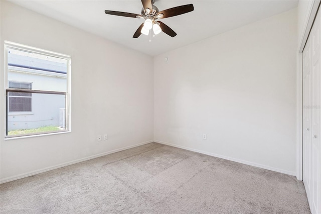 empty room with light carpet, ceiling fan, and baseboards