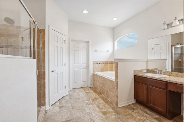 bathroom featuring a stall shower, a garden tub, and vanity