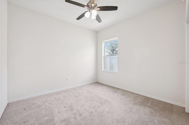 carpeted spare room with baseboards and ceiling fan