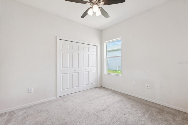 unfurnished bedroom featuring carpet flooring, a closet, baseboards, and ceiling fan