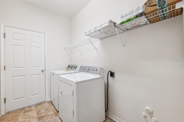 laundry room featuring washing machine and clothes dryer and baseboards