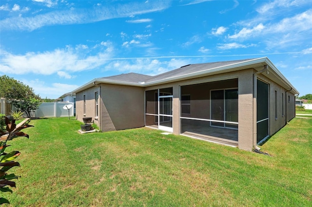 rear view of property featuring stucco siding and a sunroom