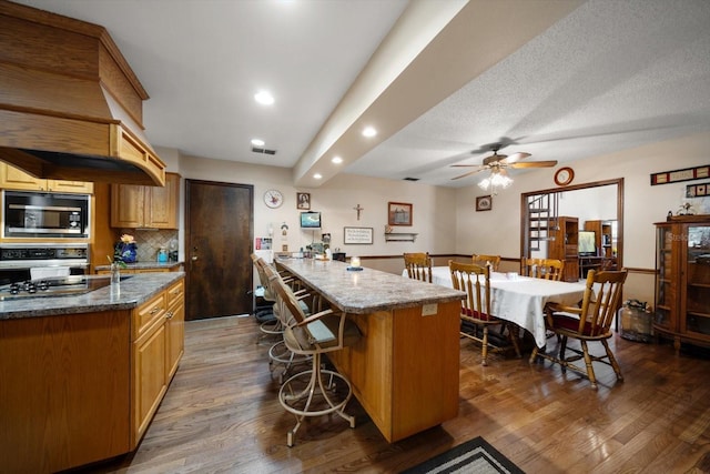 1799 Dixie Hwy, Tarpon Springs, FL 34689 - kitchen featuring appliances with stainless steel finishes, recessed lighting, a kitchen breakfast bar, stone counters, and dark wood finished floors
