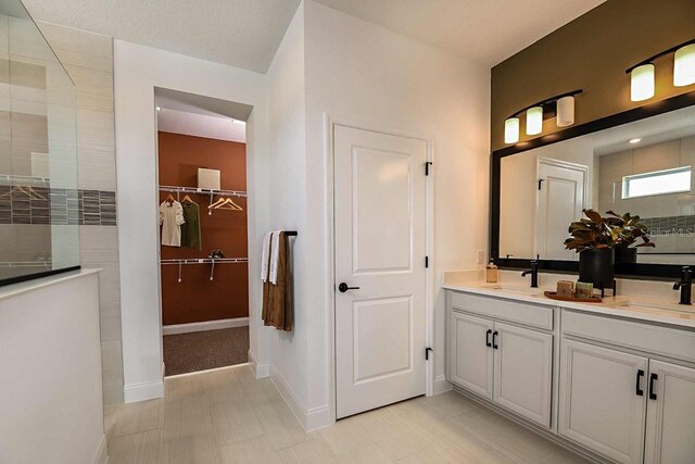 17020 Cercis Loop, Clermont, FL 34711 - bathroom with a walk in shower, baseboards, double vanity, and a walk in closet
