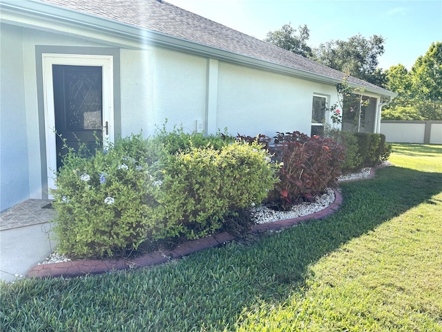 19420 Haskell Pl, Land O Lakes, FL 34638 - view of property exterior featuring a shingled roof and stucco siding