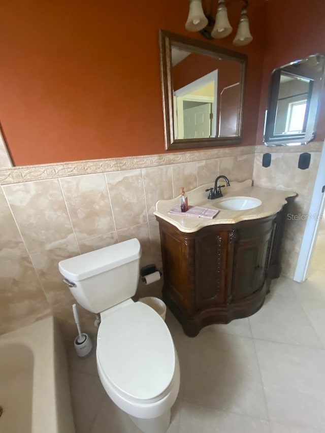 11014 Peking Pl, Tampa, FL 33624 - full bath featuring tile walls, tile patterned flooring, wainscoting, vanity, and toilet