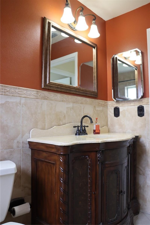 11014 Peking Pl, Tampa, FL 33624 - half bathroom featuring tile walls, toilet, vanity, and wainscoting