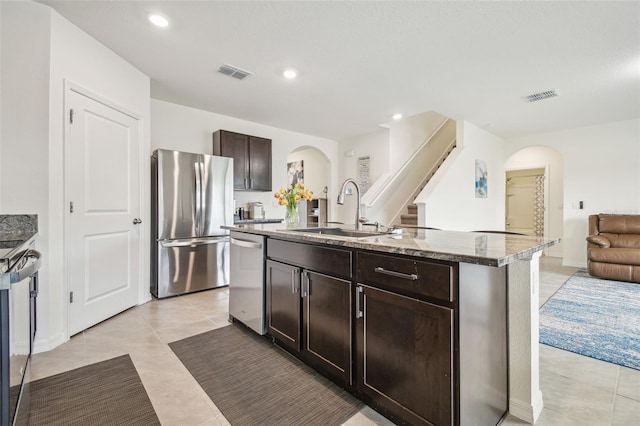 33524 Elm Hill Br, Wesley Chapel, FL 33545 - kitchen with arched walkways, appliances with stainless steel finishes, a sink, stone countertops, and recessed lighting