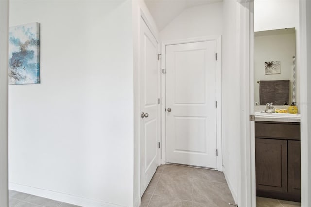 33524 Elm Hill Br, Wesley Chapel, FL 33545 - hallway featuring light tile patterned floors, a sink, vaulted ceiling, and baseboards