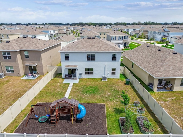 33524 Elm Hill Br, Wesley Chapel, FL 33545 - rear view of house with a playground, stucco siding, a residential view, central AC, and a shingled roof