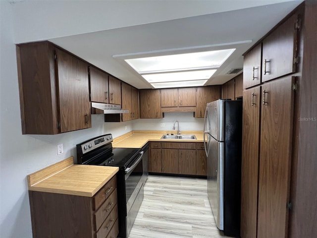 14725 Morning Dr, Lutz, FL 33559 - kitchen with appliances with stainless steel finishes, a sink, under cabinet range hood, light countertops, and light wood-type flooring