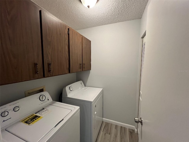14725 Morning Dr, Lutz, FL 33559 - laundry area featuring cabinet space, independent washer and dryer, light wood-style floors, a textured ceiling, and baseboards