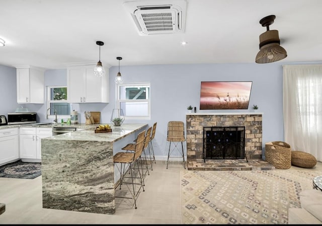 1210 Bay Palm Blvd, Indian Rocks Beach, FL 33785 - kitchen with appliances with stainless steel finishes, light stone countertops, white cabinets, a peninsula, and a sink