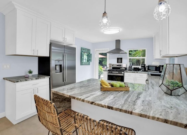 1210 Bay Palm Blvd, Indian Rocks Beach, FL 33785 - kitchen featuring appliances with stainless steel finishes, wall chimney range hood, a peninsula, and light stone counters