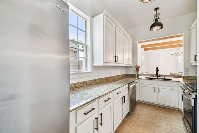 407 S Fremont Ave Unit B, Tampa, FL 33606 - kitchen with stainless steel appliances, a sink, white cabinets, decorative light fixtures, and light tile patterned floors