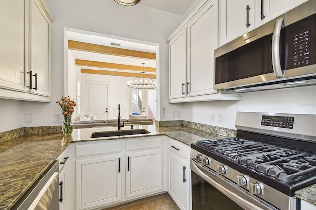 407 S Fremont Ave Unit B, Tampa, FL 33606 - kitchen with stainless steel appliances, a sink, beam ceiling, a chandelier, and dark stone counters