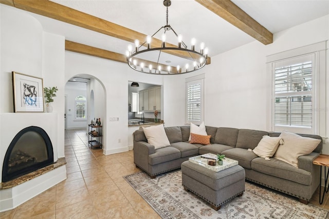 407 S Fremont Ave Unit B, Tampa, FL 33606 - living area featuring arched walkways, beamed ceiling, a chandelier, light tile patterned flooring, and baseboards