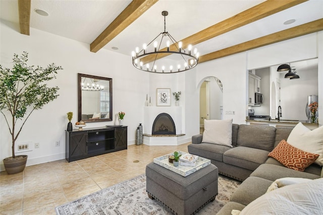 407 S Fremont Ave Unit B, Tampa, FL 33606 - living area featuring arched walkways, a chandelier, beamed ceiling, light tile patterned floors, and baseboards