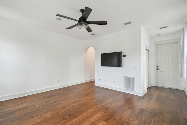 407 S Fremont Ave Unit B, Tampa, FL 33606 - unfurnished living room with dark wood-style floors, arched walkways, a ceiling fan, and baseboards