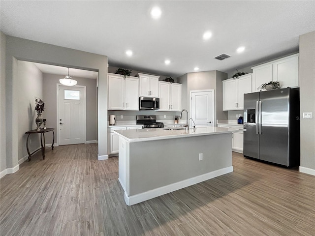16913 Anchor Root St, Wimauma, FL 33598 - kitchen featuring appliances with stainless steel finishes, a sink, wood finished floors, light countertops, and baseboards