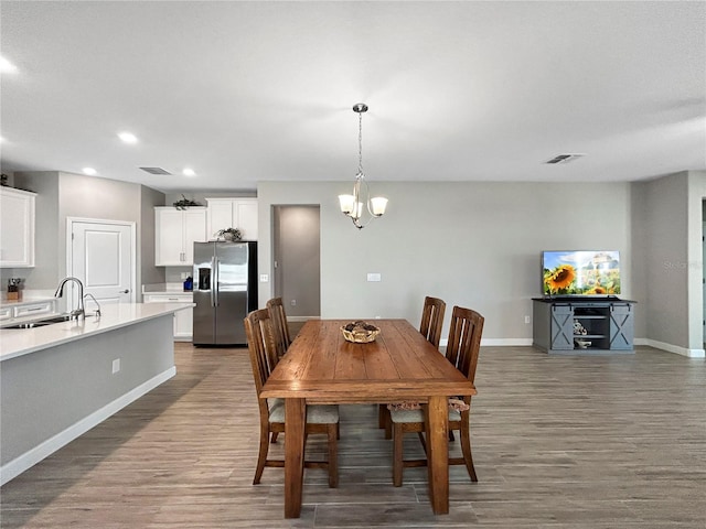 16913 Anchor Root St, Wimauma, FL 33598 - dining area with wood finished floors, baseboards, recessed lighting, and a chandelier