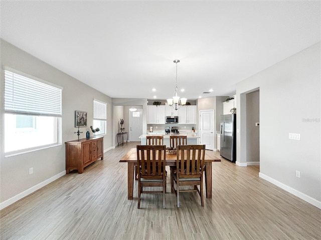 16913 Anchor Root St, Wimauma, FL 33598 - dining area with a chandelier, baseboards, light wood-style flooring, and recessed lighting
