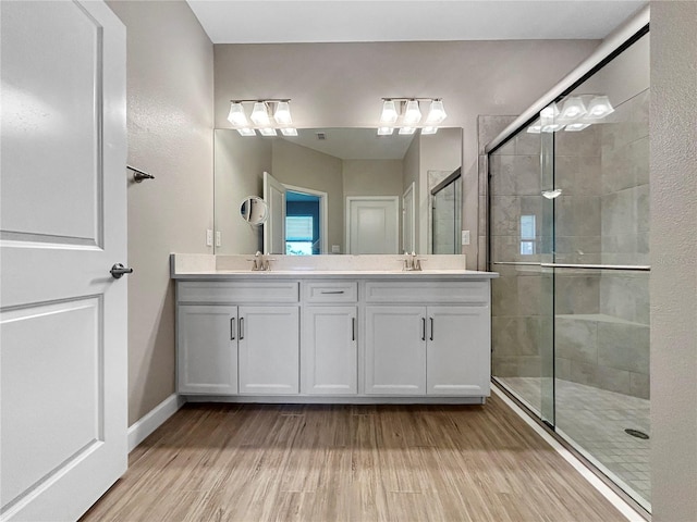 16913 Anchor Root St, Wimauma, FL 33598 - bathroom featuring double vanity, a stall shower, wood finished floors, and baseboards