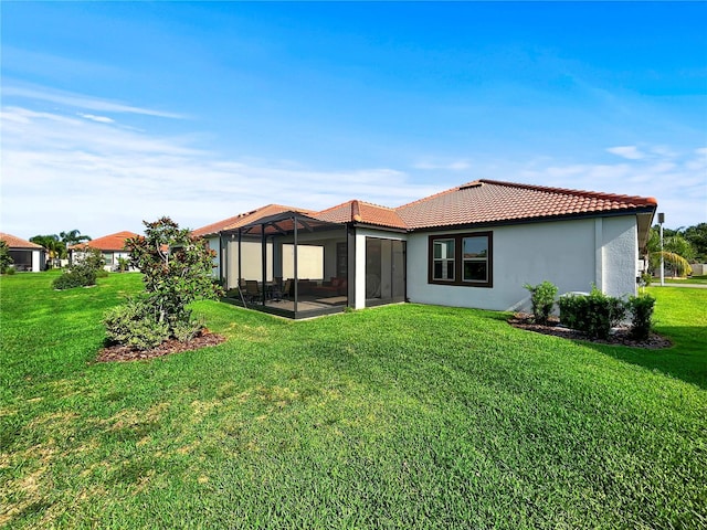 16913 Anchor Root St, Wimauma, FL 33598 - rear view of house with a tiled roof, stucco siding, a yard, and a sunroom