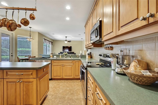 12012 Cromwell Way, Spring Hill, FL 34609 - kitchen featuring appliances with stainless steel finishes, a sink, a peninsula, ceiling fan, and dark countertops
