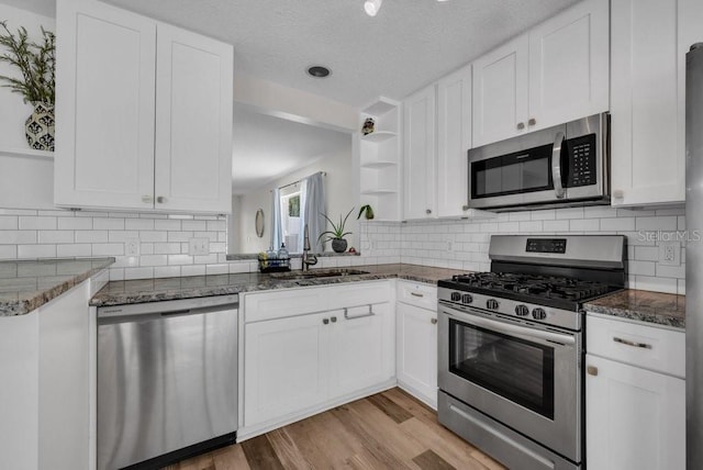 5865 Meadowpark Pl, Lithia, FL 33547 - kitchen with stainless steel appliances, open shelves, a sink, white cabinetry, and a textured ceiling