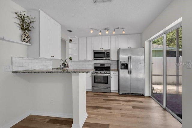 5865 Meadowpark Pl, Lithia, FL 33547 - kitchen with stainless steel appliances, open shelves, white cabinetry, light wood finished floors, and a textured ceiling