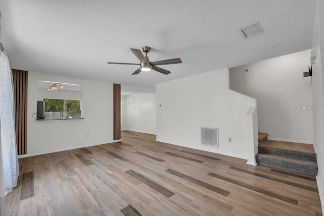5865 Meadowpark Pl, Lithia, FL 33547 - unfurnished living room with a ceiling fan, wood finished floors, stairs, a textured ceiling, and baseboards
