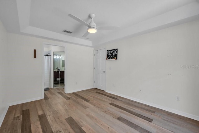 5865 Meadowpark Pl, Lithia, FL 33547 - unfurnished room featuring wood finished floors, ceiling fan, baseboards, and a tray ceiling