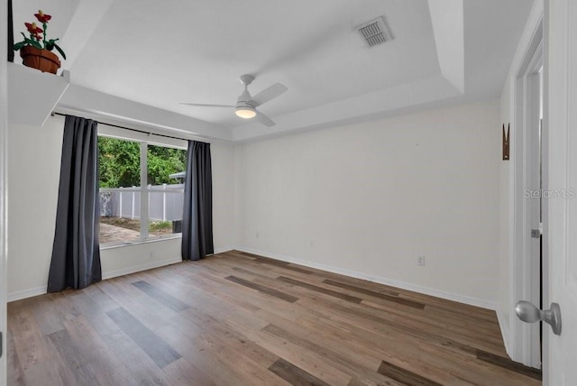 5865 Meadowpark Pl, Lithia, FL 33547 - unfurnished room featuring wood finished floors, ceiling fan, baseboards, and a raised ceiling