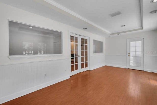 5865 Meadowpark Pl, Lithia, FL 33547 - spare room featuring french doors, wood finished floors, ornamental molding, a tray ceiling, and baseboards