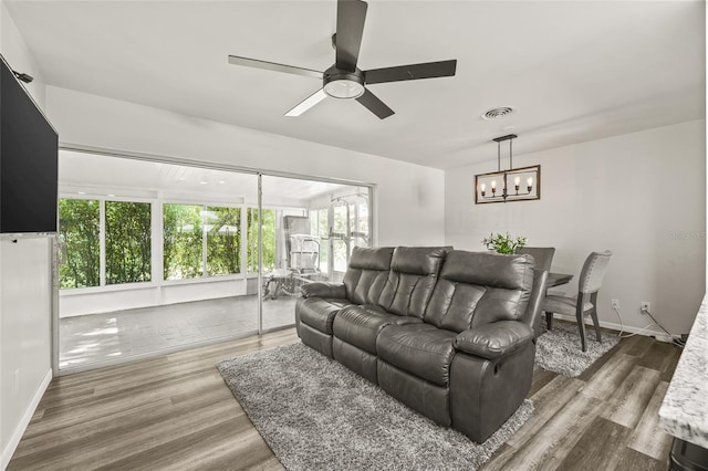1459 Joel Ln, Clearwater, FL 33755 - living area featuring a chandelier, a ceiling fan, wood finished floors, and baseboards
