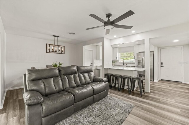 1459 Joel Ln, Clearwater, FL 33755 - living room featuring light wood finished floors, ceiling fan, recessed lighting, a chandelier, and baseboards