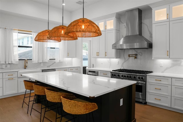 403 E Davis Blvd, Tampa, FL 33606 - kitchen with high end stove, wall chimney exhaust hood, a center island, a sink, and plenty of natural light