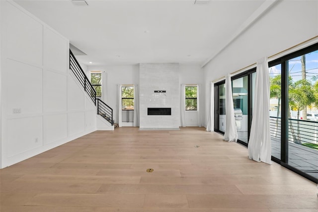 403 E Davis Blvd, Tampa, FL 33606 - unfurnished living room with light wood-style flooring, stairway, and a large fireplace