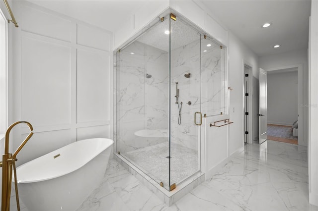 403 E Davis Blvd, Tampa, FL 33606 - full bathroom with marble tiled floors, a decorative wall, recessed lighting, a marble finish shower, and a freestanding bath