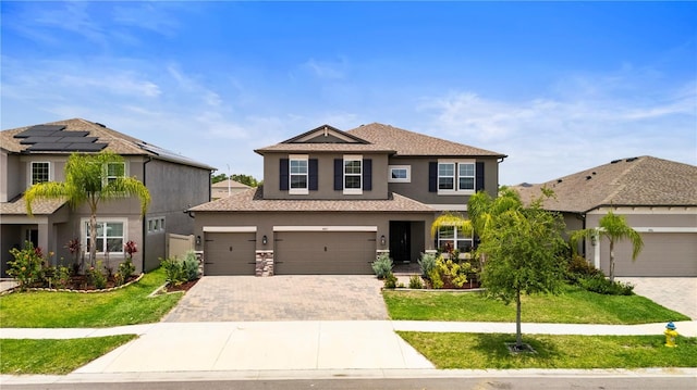 4917 Eagle Rock Dr, Wimauma, FL 33598 - traditional home with stucco siding, decorative driveway, a front lawn, and an attached garage